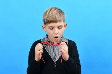 Oğlan, lensleri silecek gözlük olmayan kırmızı bardaklara nefes alıyor..