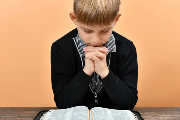 Uma Bíblia Aberta Frente Uma Criança Orante Com Mãos Dobradas — Fotografia de Stock