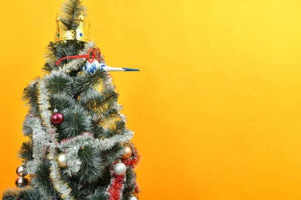 鼻の代わりに赤い眼鏡とおもちゃを身に着けて頭の上に冠を持つクリスマスツリー — ストック写真