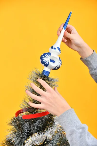 孩子们装饰圣诞树 并在树枝顶上挂上一个节庆玩具 — 图库照片