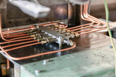 Metal fabrikasının hidrolik yağ istasyonunun basınç dağıtıcısının bakır boruları..