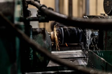 Uçan kıvılcımlar ve su soğutuculu öğütme makinesinin dış yüzeyindeki metalin yüksek hassasiyetli mekanizması..