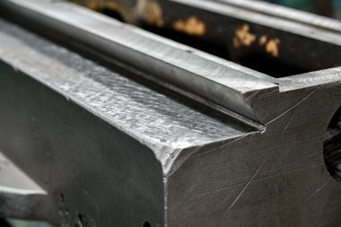 Metal işçiliği yapan bir makinenin kılavuz yatağının kazınmış yüzeyine yakın çekim. Mekanik ekipman tamir atölyesi.