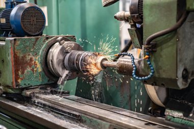 Uçan kıvılcımlar ve su soğutuculu öğütme makinesinin dış yüzeyindeki metalin yüksek hassasiyetli mekanizması..