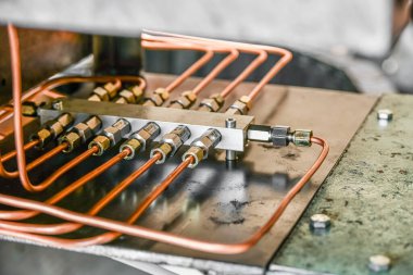 Metal fabrikasının hidrolik yağ istasyonunun basınç dağıtıcısının bakır boruları..