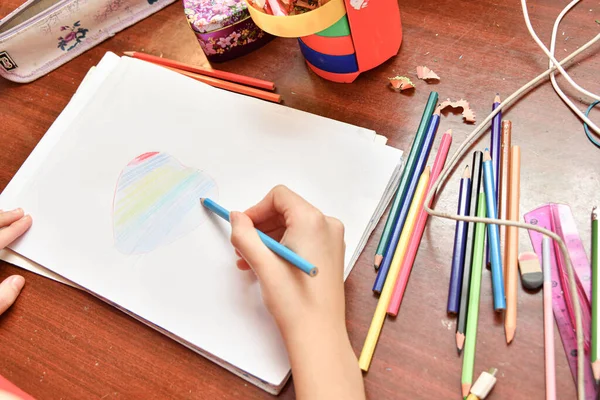 Dziecko Rysuje Serce Papierze Kolorowych Ołówków Domu Przy Stole — Zdjęcie stockowe