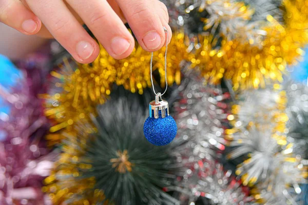 人間の手でクリスマスの新年の木はヤシの木でお祝いのおもちゃを保持 — ストック写真