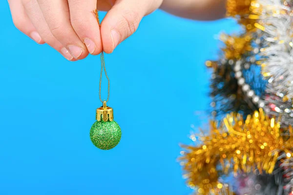クリスマスツリーを背景に男の手にお正月のおもちゃ — ストック写真