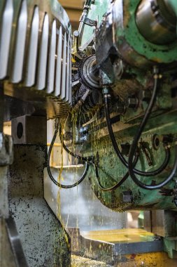 Petrol soğutmalı bir dişli kesme makinesinin dişini üretip keserek..