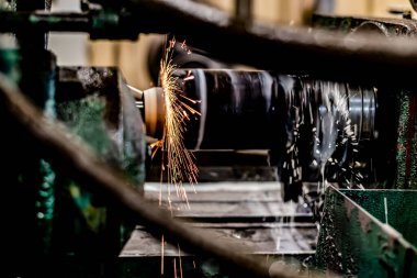 Uçan kıvılcımlar ve su soğutuculu öğütme makinesinin dış yüzeyindeki metalin yüksek hassasiyetli mekanizması..