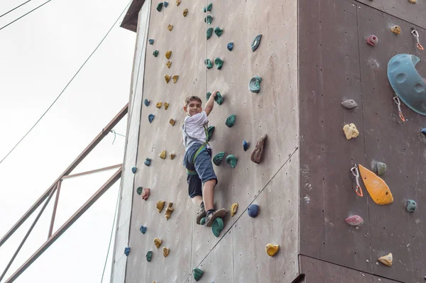 Chłopiec Wspina Się Szczyt Ściany Wspinaczkowej Sportowym Parku Ściana Wspinaczkowa — Zdjęcie stockowe