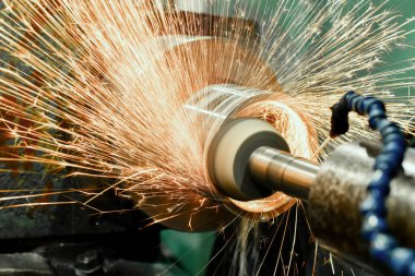 Yuvarlak bir parçanın iç yüzeyi, silindirik bir öğütme makinesinde aşındırıcı bir tekerlekle yüksek hassasiyetle bitiriliyor..