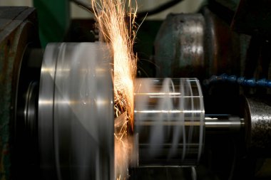 Kıvılcımlı dairesel öğütme makinesinde aşındırıcı tekerleği olan öğütücü metal. Parçalayarak metal işleme, aşındırıcı tekerlekten kıvılcımlar.