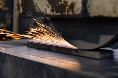 Bir yüzey öğütücüsünde metali öğütüp bitirirken yıpratıcı tekerlekten kıvılcımlar uçuşur..