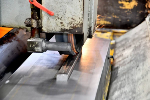 Mechanical processing of metal products. Grinding and finishing of metal on a surface grinder with sparks.