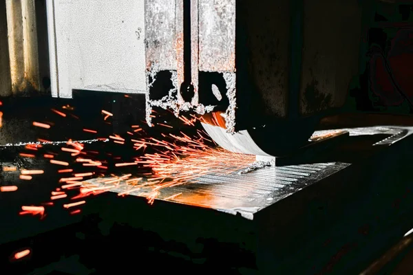 Mechanical processing of metal products. Grinding and finishing of metal on a surface grinder with sparks.