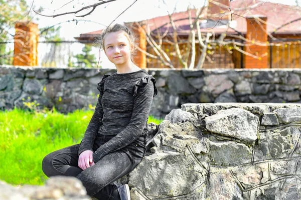 Una Adolescente Jardín Ciudad Sienta Una Piedra Decorativa Mira Hacia —  Fotos de Stock