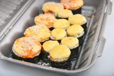 Japon suşi yemekleri, ton balığı, karides, somon, yengeç, avokado, uramaki, hosomaki ve nigiri. Plastik ambalajda farklı rulo çeşitleri.