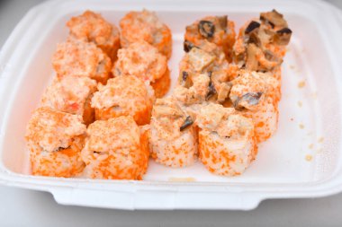 Sos, karides ve havyarlı plastik ambalajlı bir suşi..