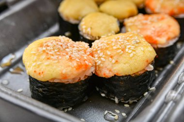 Japon suşi yemekleri, ton balığı, karides, somon, yengeç, avokado, uramaki, hosomaki ve nigiri. Plastik ambalajda farklı rulo çeşitleri.