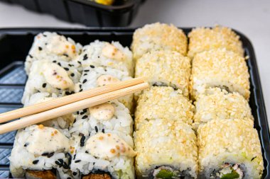 Suşi için bambu çubukları. Çeşitli rulo, maki, nigiri plastik ambalaj çeşitleri.