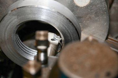 Torna tezgahında özel bir mekanik kesiciyle yuvalı bir fındıkta iç iplik kesmek..