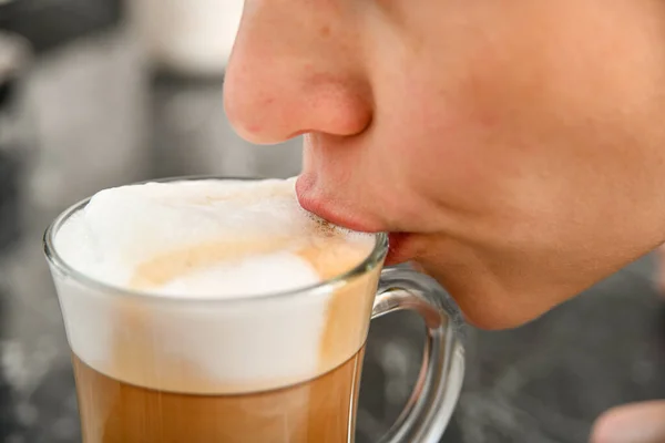 唇で泡を飲む少女の手に泡でコーヒー 女の子はコーヒーを飲みますクローズアップ — ストック写真
