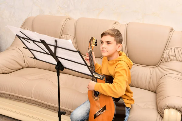 Chico Está Aprendiendo Tocar Guitarra Delante Las Notas Enseñando Música —  Fotos de Stock