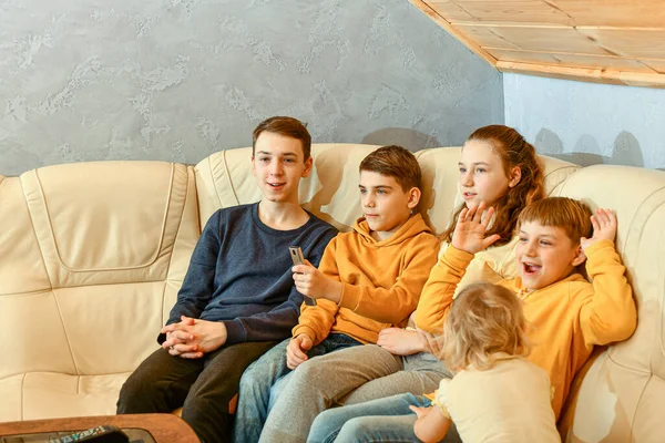 Діти Дивляться Телевізор Сидячи Шкіряному Дивані Емоційно Махаючи Руками — стокове фото