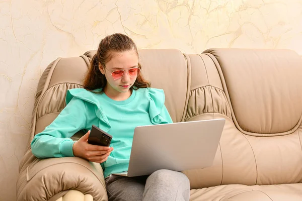 Молода Дівчина Ноутбуком Сидить Офісі Шкіряному Дивані Тримає Телефон Руці — стокове фото