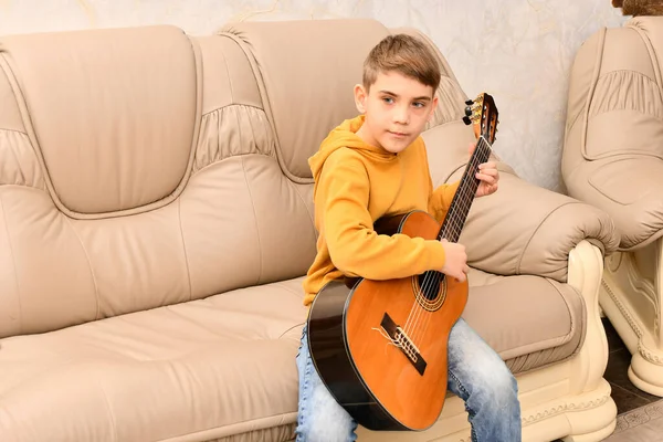 Garçon Est Assis Sur Canapé Cuir Joue Guitare — Photo
