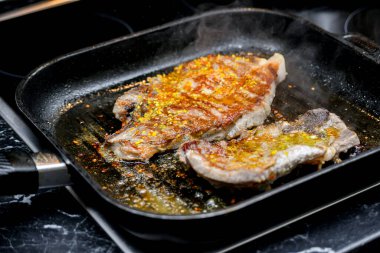 Baharatlı bir tavada kızarmış et, parçalara ayrılmış..