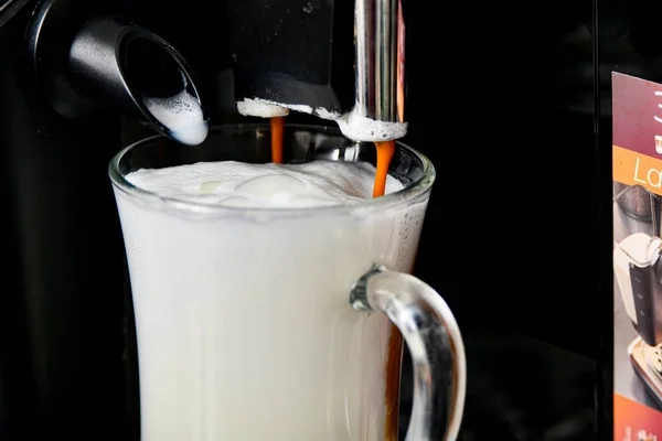 杯子里有泡沫和牛奶 用咖啡机配制 — 图库照片