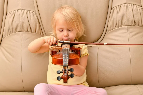 Uma Menina Com Violino Nas Mãos Senta Sofá Couro — Fotografia de Stock