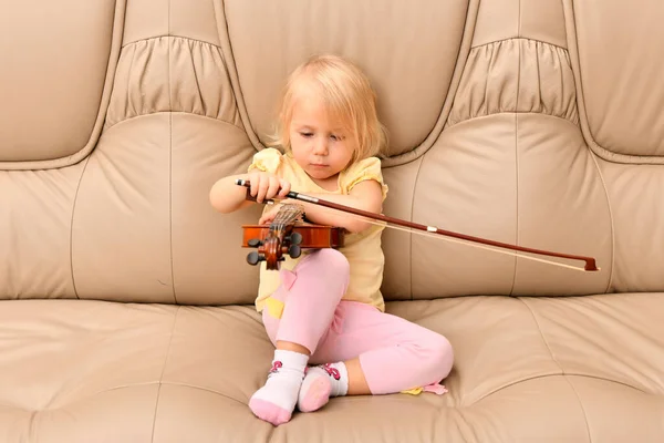 Uma Menina Com Violino Nas Mãos Senta Sofá Couro — Fotografia de Stock