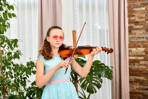 Uma Menina Óculos Sol Toca Violino Casa Entre Plantas Verdes — Fotografia de Stock