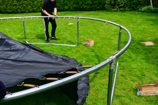 Boy Assembles New Trampoline Stretches Springs Jump — Stockfoto