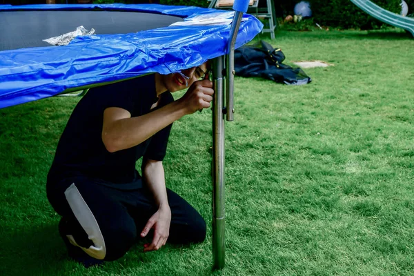 Boy Assembles New Trampoline Stretches Springs Jump — Stockfoto