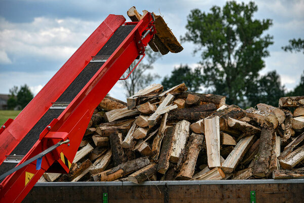 Sawn and chopped firewood after chopping and sawing is sent to a firewood carriage.