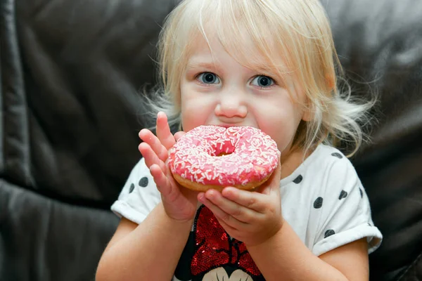 Uma Menina Come Delicioso Donut Vermelho Com Cobertura — Fotografia de Stock