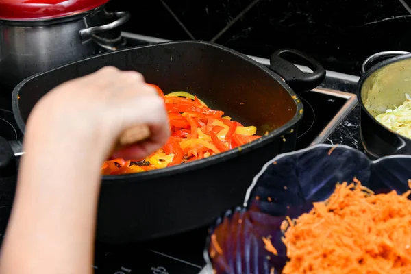 Una Mujer Cocina Revuelve Pimientos Guisados Una Sartén — Foto de Stock