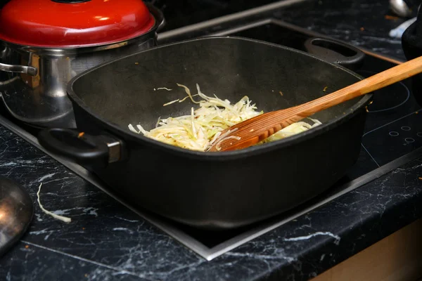 Genç yeşil lahana, mutfaktaki tavada pişiyor..