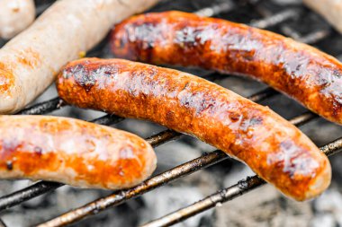 Marinated grilled sausages are fried on a fire.