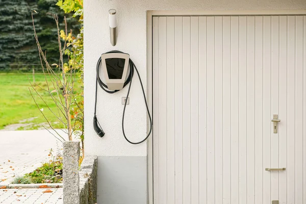 Özel bir evin garajındaki elektrikli araba için şarj istasyonu..