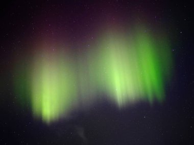 Gece gökyüzünde yeşil ve kırmızı aurora borealis.