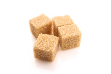Beyaz arka planda rafine şeker küpleri. Arkaplanda kahverengi şeker küpleri