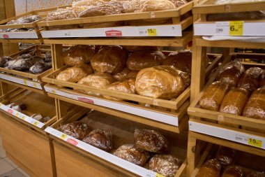 Ukrayna, Dnipropetrovsk. 05.06.2021 Bir sürü taze somun ekmek. Bir süpermarkette çeşitli fırınlanmış ürünler. Bir pastanenin vitrininde