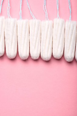 Pembe arka planda tıbbi kadın tamponu. Kadınlar için hijyenik beyaz tampon. Pamuklu çubuk. Regl, korunma aracı. Kırmızı arkaplanda tamponlar.