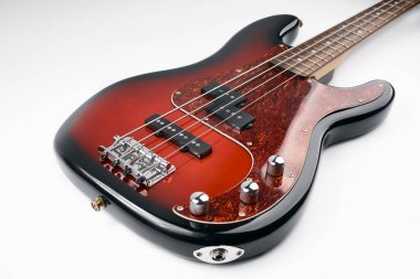 Metalik hacimli üç baslı gitar topuzları. Elektro gitar. Kırmızı elektro bas gitar yakın plan. Müzik aleti. Müziği. Dört telli. Grif.