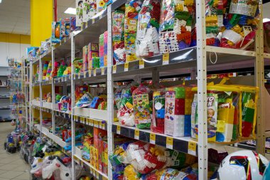 Ukrayna, Dnepropetrovsk.05.06.2021 Rafı birçok renkli oyuncakla. Çocuk oyuncakçılarının geçmişi bulanık. Bir mağazadaki raflarda çeşitli inşaat oyuncakları. Çocuk mağazasındaki oyuncak renkli plastik arabalar.